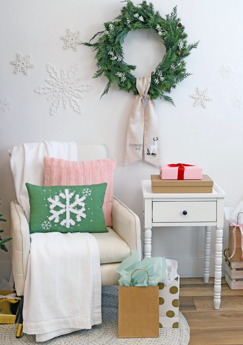 Tan chair with green Blizzard Bliss Pillow and wreath hanging to the right with Comfort & Joy Wreath Sash design.