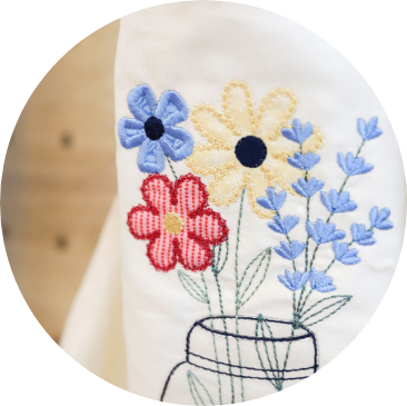 Circle Image, Closeup of Baubles & Boughs Teat Towel and on-the-hoop buttonholes.